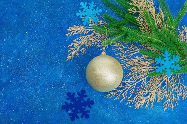 Geleneksel yeni yıl kompozisyonu. Şenlikli dekor, karlı Noel ağacı dalları, balolar. Tatil zamanı, desenli mavi arkaplan, üst görünüm