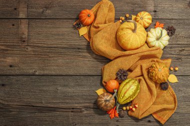 Ahşap arka planda sonbahar kompozisyonu. Süslü balkabağı, böğürtlen ve sonbahar yaprakları çeşitleri. Geleneksel sembol, şenlik tasarımı, üst görünüm