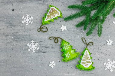 Geleneksel Yeni Yıl kompozisyonu. Şenlikli el yapımı dekor, Noel ağaçlarının haçla süslendiğini hissetti. Tatil zamanı, dokulu gri arkaplan, metin için yer