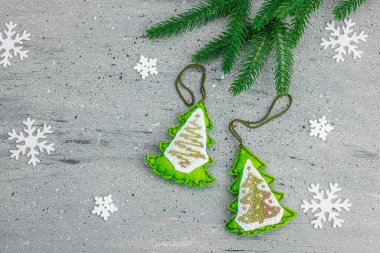 Geleneksel Yeni Yıl kompozisyonu. Şenlikli el yapımı dekor, Noel ağaçlarının haçla süslendiğini hissetti. Tatil zamanı, dokulu gri arkaplan, metin için yer