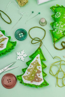 Geleneksel Yeni Yıl kompozisyonu. Şenlikli el yapımı dekor, Noel ağaçlarının haçla süslendiğini hissetti. Tatil zamanı konsepti, açık yeşil arkaplan, üst görünüm
