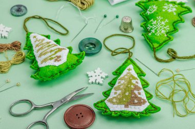 Geleneksel Yeni Yıl kompozisyonu. Şenlikli el yapımı dekor, Noel ağaçlarının haçla süslendiğini hissetti. Tatil zamanı konsepti, açık yeşil arkaplan, kapat