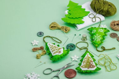 Geleneksel Yeni Yıl kompozisyonu. Şenlikli el yapımı dekor, Noel ağaçlarının haçla süslendiğini hissetti. Tatil zamanı kavramı, açık yeşil arkaplan, kopyalama alanı