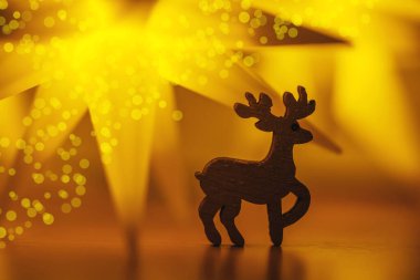 Bayramlık Noel kartı. Yeni yıl tatili konsepti. Parlak yıldızlar, geyik figürü, geleneksel semboller. Metin için yer, bokeh etkisi