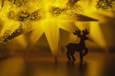 Bayramlık Noel kartı. Yeni yıl tatili konsepti. Parlak yıldızlar, geyik figürü, geleneksel semboller. Metin için yer, bokeh etkisi