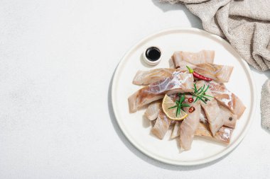 Çiğ pollock (Pollachius virens) fileto. Sağlıklı yaşam tarzı için taze balık. Limon, biberiye, deniz tuzu, kırmızı biber, karabiber. Hafif taş zemin, düz zemin, üst manzara