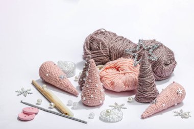 Örgü örmek için bir demet iplik. Tığ işi Noel ağaçları, boncuklar, el yapımı, kış hobisi. Açık gri arkaplan üzerindeki dekor ve özel sanatsal araçlar, boşluğu kopyala