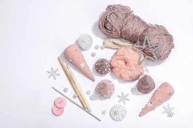 Örgü örmek için bir demet iplik. Tığ işi Noel ağaçları, boncuklar, el yapımı, kış hobisi. Açık gri arkaplan, üst görünüm üzerinde özel araç gereç araçları