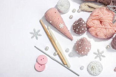 Örgü örmek için bir demet iplik. Tığ işi Noel ağaçları, boncuklar, el yapımı, kış hobisi. Açık gri arkaplan, üst görünüm üzerinde özel araç gereç araçları