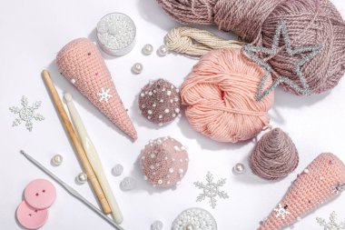 Örgü örmek için bir demet iplik. Tığ işi Noel ağaçları, boncuklar, el yapımı, kış hobisi. Açık gri arkaplan, üst görünüm üzerinde özel araç gereç araçları