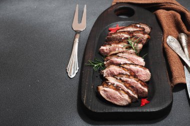 Taze portakal ve zencefilli kızarmış ördek göğsü, yemek için hazır. Lezzetli ev yemekleri, kümes hayvanları fileto. Koyu taş arkaplan, kopyalama alanı