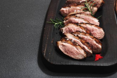 Taze portakal ve zencefilli kızarmış ördek göğsü, yemek için hazır. Lezzetli ev yemekleri, kümes hayvanları fileto. Koyu taş arkaplan, kopyalama alanı