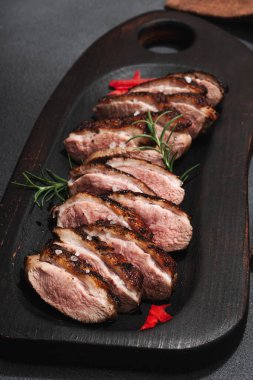 Taze portakal ve zencefilli kızarmış ördek göğsü, yemek için hazır. Lezzetli ev yemekleri, kümes hayvanları fileto. Koyu taş beton arka plan, kapat