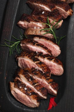 Taze portakal ve zencefilli kızarmış ördek göğsü, yemek için hazır. Lezzetli ev yemekleri, kümes hayvanları fileto. Koyu taş zemin, üst görünüm