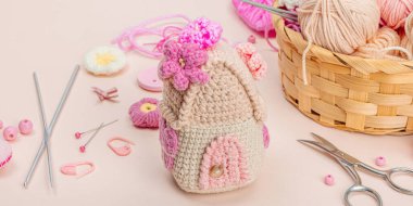 El yapımı bahar dekoru konsepti. Yaratıcı tığ işi, ev figürleri, geleneksel çiçekler ve kalpler. Kutlama kartı, yumuşak pastel kayısı arka planı, afiş biçimi