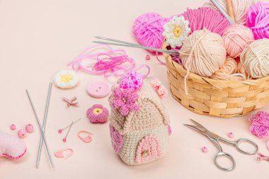 El yapımı bahar dekoru konsepti. Yaratıcı tığ işi, ev figürleri, geleneksel çiçekler ve kalpler. Kutlama kartı, yumuşak pastel kayısı arka planı, kopyalama alanı.