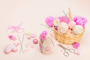 El yapımı bahar dekoru konsepti. Yaratıcı tığ işi, ev figürleri, geleneksel çiçekler ve kalpler. Kutlama kartı, yumuşak pastel kayısı arka planı, kopyalama alanı.