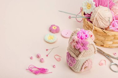 El yapımı bahar dekoru konsepti. Yaratıcı tığ işi, ev figürleri, geleneksel çiçekler ve kalpler. Kutlama kartı, yumuşak pastel kayısı arka planı, kopyalama alanı.