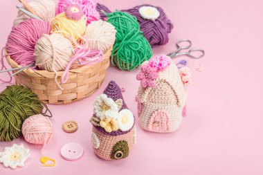 El yapımı bahar dekoru konsepti. Yaratıcı tığ işi, ev figürleri, geleneksel çiçekler falan. Kutlama kartı, yumuşak pastel pembe arka plan, kopyalama alanı.