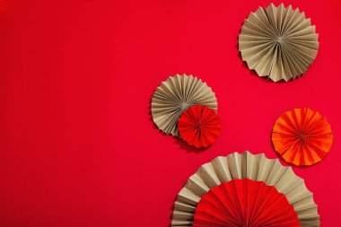 Happy Chinese New Year traditional concept. Oriental asian style paper fans on red background, minimal concept, flat lay, top view