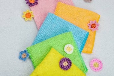 Ev işleri için parlak renkli mikrofiber havlular. Organik temizlik, çiçek tazeliği. Yıkama, el yapımı dekor, taş beton arka plan, düz döşeme, üst manzara