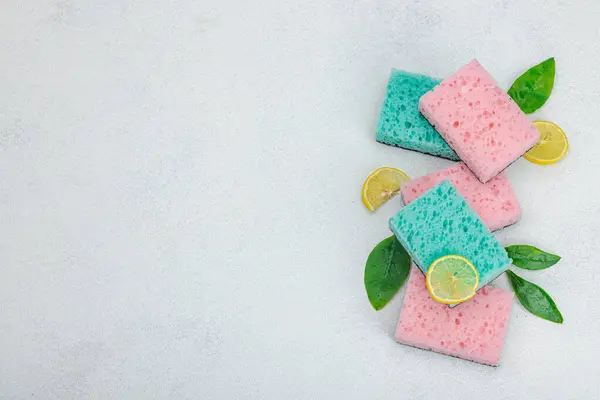 Various sponges for washing dishes. Organic cleaning concept, lemon freshness. Stone concrete background, flat lay, top view