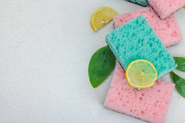 Various sponges for washing dishes. Organic cleaning concept, lemon freshness. Stone concrete background, flat lay, top view