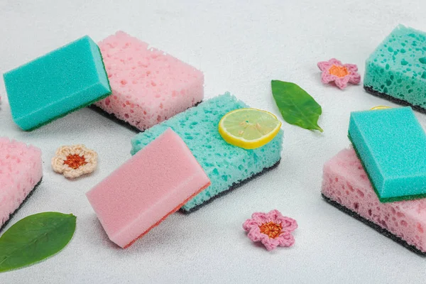 Various sponges for washing dishes. Organic cleaning concept, lemon freshness. Stone concrete background, flat lay, close up