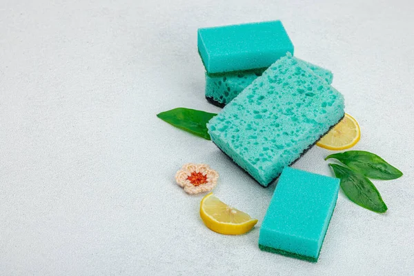 Various sponges for washing dishes. Organic cleaning concept, lemon freshness. Stone concrete background, flat lay, copy space