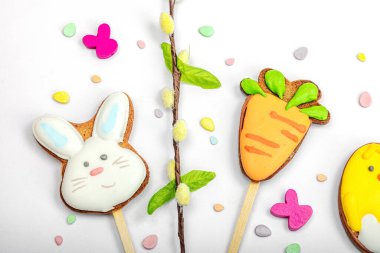 Geleneksel Paskalya kurabiyeleri, yenilebilir şenlik dekorları. Ev yapımı pişirme konsepti, tatlı tatlılar. Tebrik kartı, beyaz arkaplan, düz yatak, üst görünüm