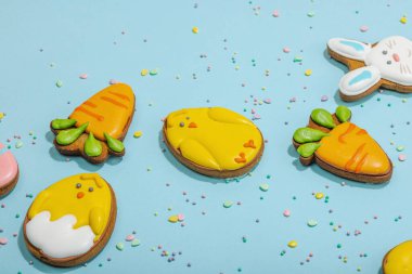 Geleneksel Paskalya kurabiyeleri, yenilebilir şenlik dekorları. Ev yapımı pişirme konsepti, tatlı tatlılar. Tebrik kartı, mavi arkaplan, düz yatış, kopyalama alanı