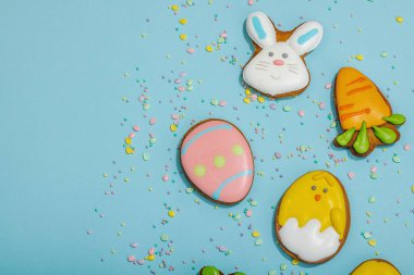 Geleneksel Paskalya kurabiyeleri, yenilebilir şenlik dekorları. Ev yapımı pişirme konsepti, tatlı tatlılar. Tebrik kartı, mavi arkaplan, düz yatak, üst görünüm