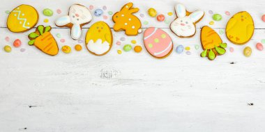 Geleneksel Paskalya kurabiyeleri, yenilebilir şenlik dekorları. Ev yapımı pişirme konsepti, tatlı tatlılar. Tebrik kartı, beyaz ahşap arkaplan, düz yatak, pankart biçimi