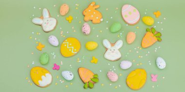 Geleneksel Paskalya kurabiyeleri, yenilebilir şenlik dekorları. Ev yapımı pişirme konsepti, tatlı tatlılar. Tebrik kartı, pastel yeşil arkaplan, düz yatış, pankart biçimi