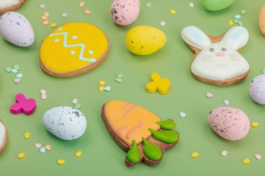 Geleneksel Paskalya kurabiyeleri, yenilebilir şenlik dekorları. Ev yapımı pişirme konsepti, tatlı tatlılar. Tebrik kartı, pastel yeşil arka plan, düz yatak, yakın çekim.