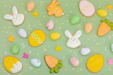 Geleneksel Paskalya kurabiyeleri, yenilebilir şenlik dekorları. Ev yapımı pişirme konsepti, tatlı tatlılar. Tebrik kartı, pastel yeşil arkaplan, düz yatak, üst görünüm