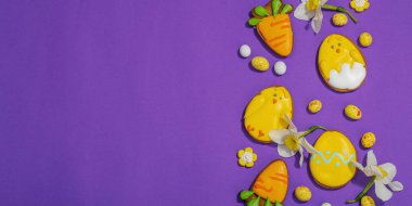 Geleneksel Paskalya kurabiyeleri, yenilebilir şenlik dekorları. Ev yapımı pişirme konsepti, tatlı tatlılar. Tebrik kartı, mor arkaplan, düz yatış, pankart biçimi