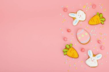 Geleneksel Paskalya kurabiyeleri, yenilebilir şenlik dekorları. Ev yapımı pişirme konsepti, tatlı tatlılar. Tebrik kartı, pembe arkaplan, düz yatak, üst manzara