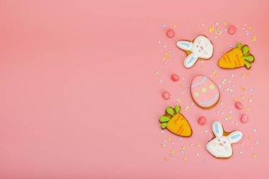 Geleneksel Paskalya kurabiyeleri, yenilebilir şenlik dekorları. Ev yapımı pişirme konsepti, tatlı tatlılar. Tebrik kartı, pembe arkaplan, düz yatak, üst manzara