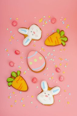 Geleneksel Paskalya kurabiyeleri, yenilebilir şenlik dekorları. Ev yapımı pişirme konsepti, tatlı tatlılar. Tebrik kartı, pembe arkaplan, düz yatak, üst manzara