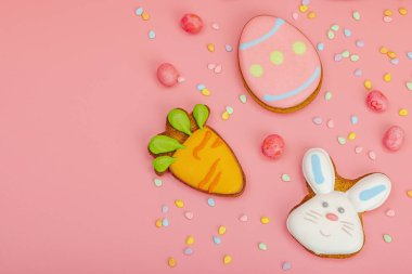 Geleneksel Paskalya kurabiyeleri, yenilebilir şenlik dekorları. Ev yapımı pişirme konsepti, tatlı tatlılar. Tebrik kartı, pembe arkaplan, düz yatak, üst manzara