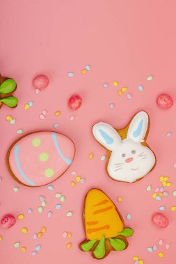 Geleneksel Paskalya kurabiyeleri, yenilebilir şenlik dekorları. Ev yapımı pişirme konsepti, tatlı tatlılar. Tebrik kartı, pembe arkaplan, düz yatak, üst manzara