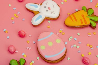 Geleneksel Paskalya kurabiyeleri, yenilebilir şenlik dekorları. Ev yapımı pişirme konsepti, tatlı tatlılar. Tebrik kartı, pembe arka plan, düz yatak, yakın çekim.
