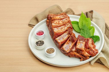 Baharat ve bitkilerle marine edilmiş çiğ pirzola. Mangal partisi için geleneksel malzeme, piknik konsepti. Taze etli kompozisyon, keten peçete, modaya uygun tabak, düz masa, tahta masa, kopyalama alanı