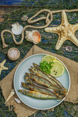 Taze limon ve bitkilerle tütsülenmiş eritilmiş. Deniz dekorlu tuzlu balık. Moda yemeği, deniz ipi. Mavi denizcilik ahşap arka plan, üst görünüm