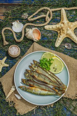 Taze limon ve bitkilerle tütsülenmiş eritilmiş. Deniz dekorlu tuzlu balık. Moda yemeği, deniz ipi. Mavi denizcilik ahşap arka plan, üst görünüm