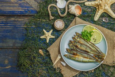 Taze limon ve bitkilerle tütsülenmiş eritilmiş. Deniz dekorlu tuzlu balık. Moda yemeği, deniz ipi. Mavi denizcilik ahşap arka plan, üst görünüm
