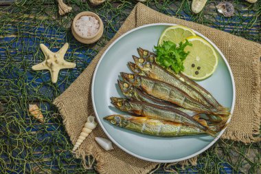 Taze limon ve bitkilerle tütsülenmiş eritilmiş. Deniz dekorlu tuzlu balık. Moda yemeği, deniz ipi. Mavi denizcilik ahşap arka plan, üst görünüm
