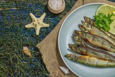 Taze limon ve bitkilerle tütsülenmiş eritilmiş. Deniz dekorlu tuzlu balık. Moda yemeği, deniz ipi. Mavi denizcilik ahşap arka plan, üst görünüm