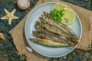 Taze limon ve bitkilerle tütsülenmiş eritilmiş. Deniz dekorlu tuzlu balık. Moda yemeği, deniz ipi. Mavi denizcilik ahşap arka plan, üst görünüm
